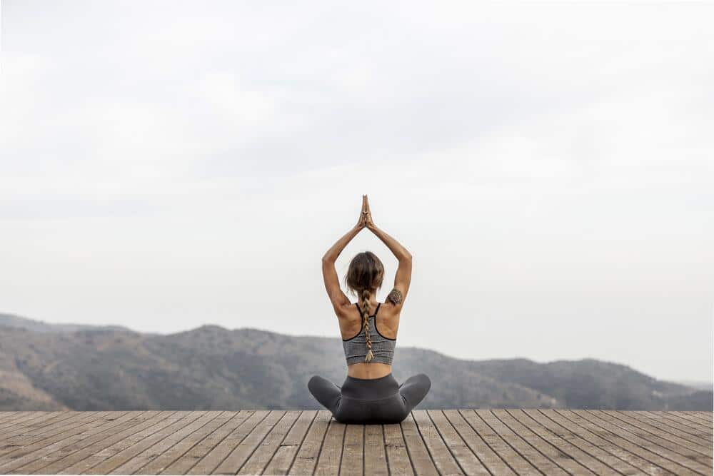 mujer haciendo yoga aire libre