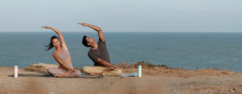 alumnos practicando yoga en la playa