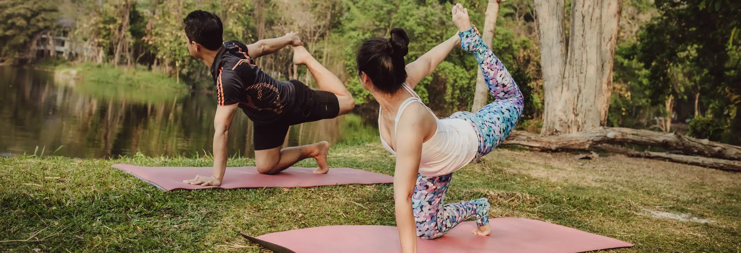 amantes del yoga estiramiento cerca del lago