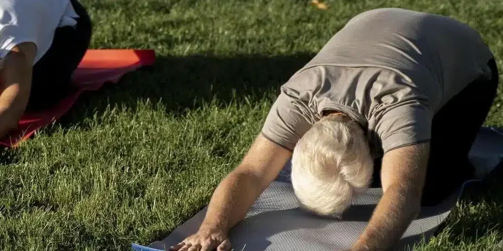 personas de angulo alto al aire libre haciendo yoga